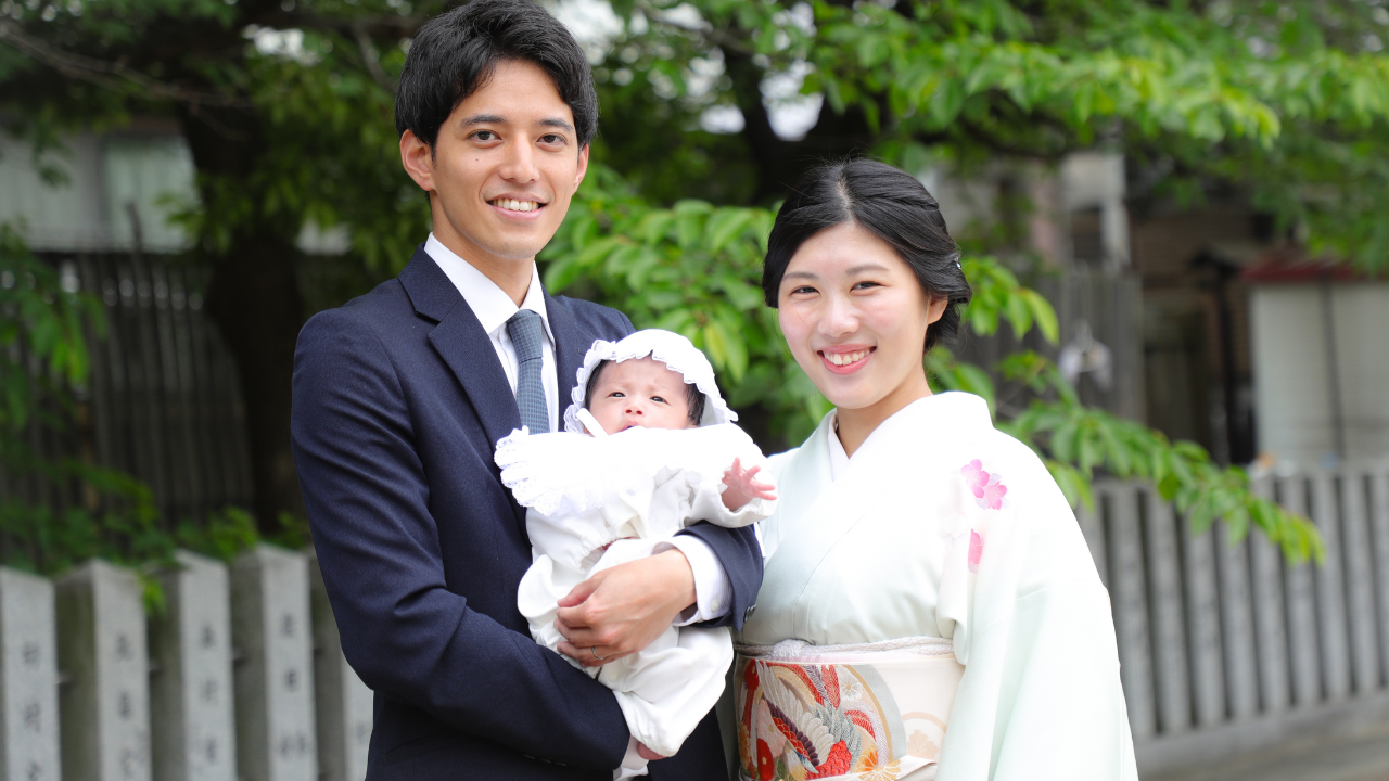 お宮参りの正装で新生児を抱く夫婦
