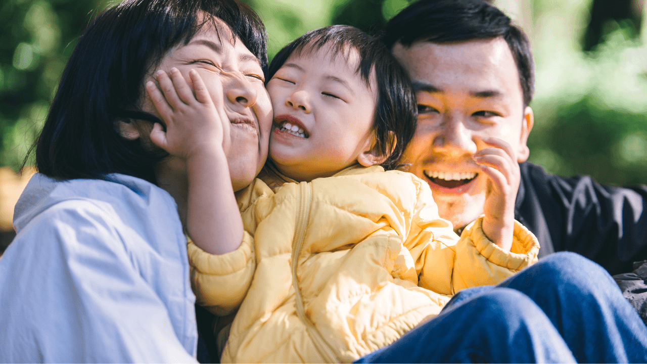 屋外で子どもと笑い合う家族