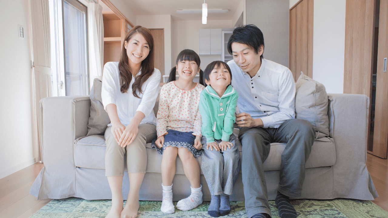 リビングのソファに並ぶ4人家族