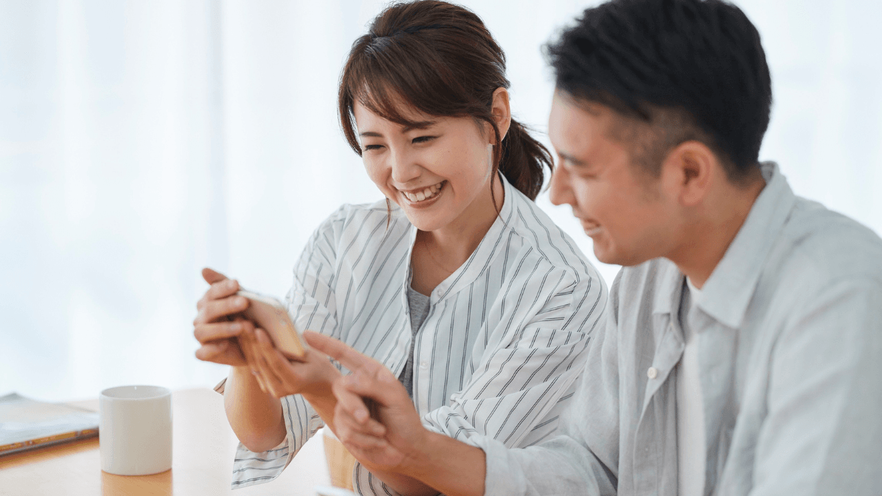 スマホを一緒に見て笑う夫婦