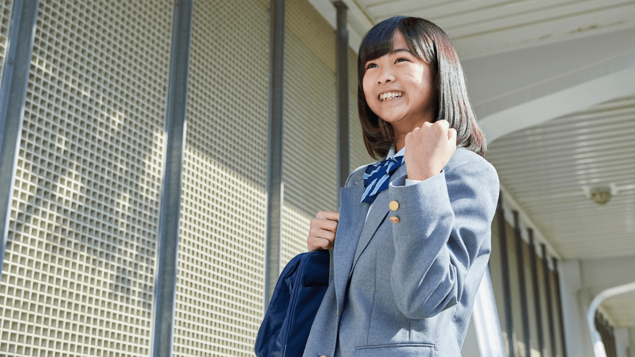 制服姿でガッツポーズをする女子学生