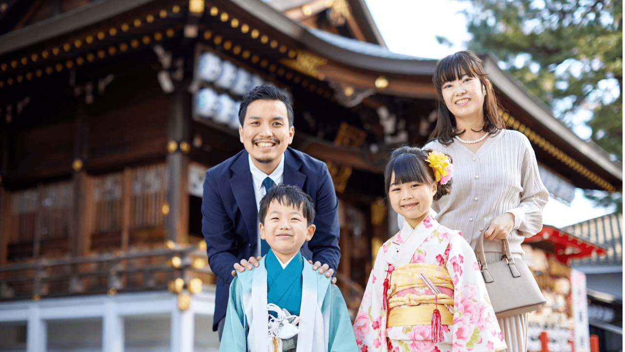 神社で七五三の記念撮影をする家族
