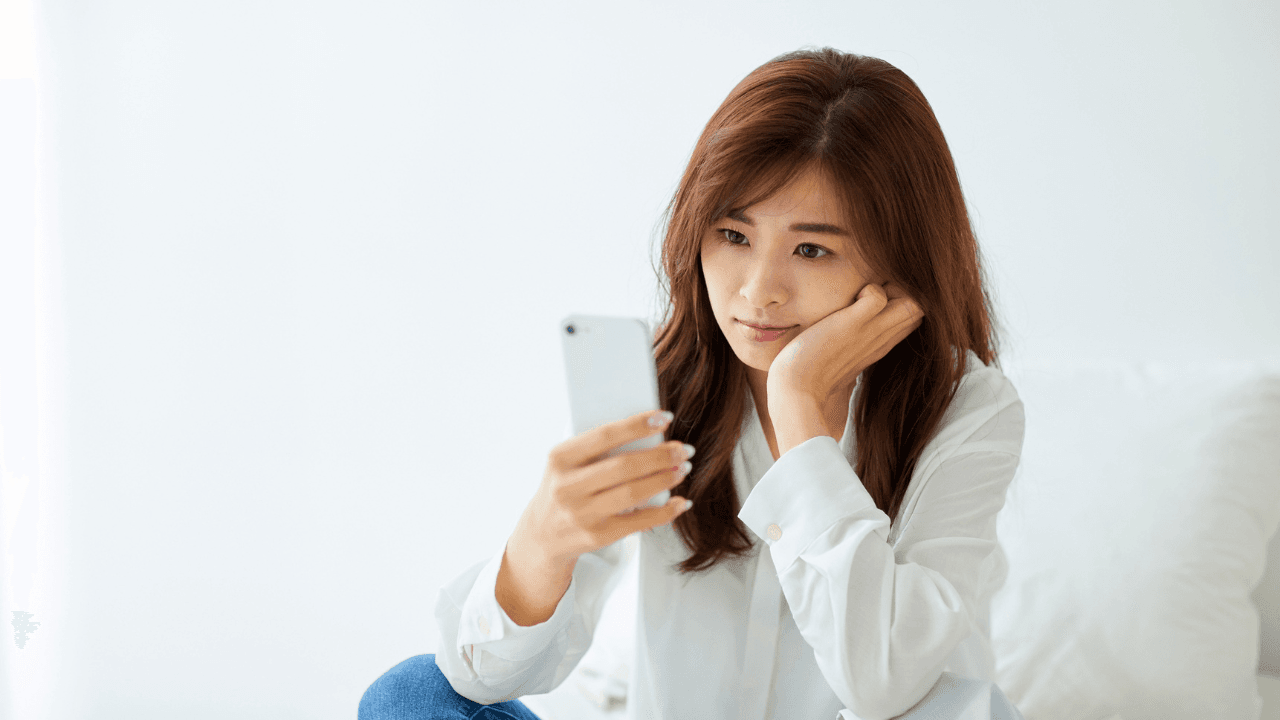 スマホを見て物思いにふける女性