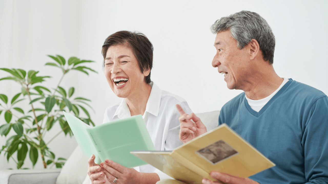 本を見て笑い合うシニア夫婦