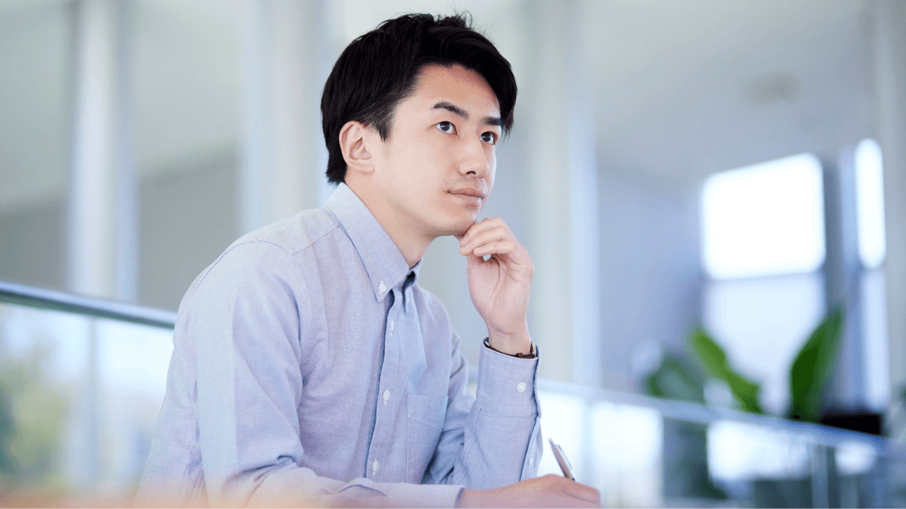 オフィスで考えごとをする男性